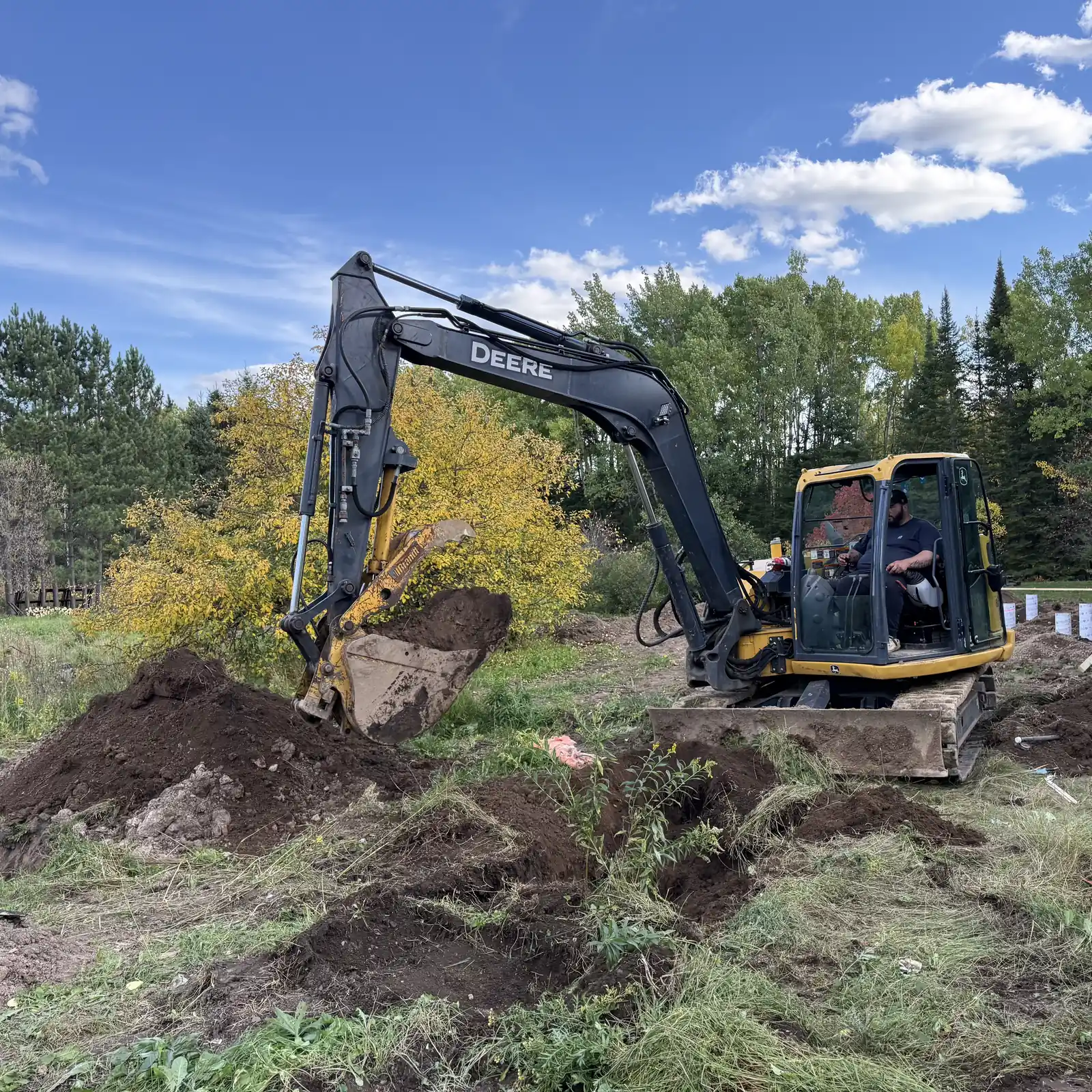 John Deere excavator digging at a Superior Yard Works site