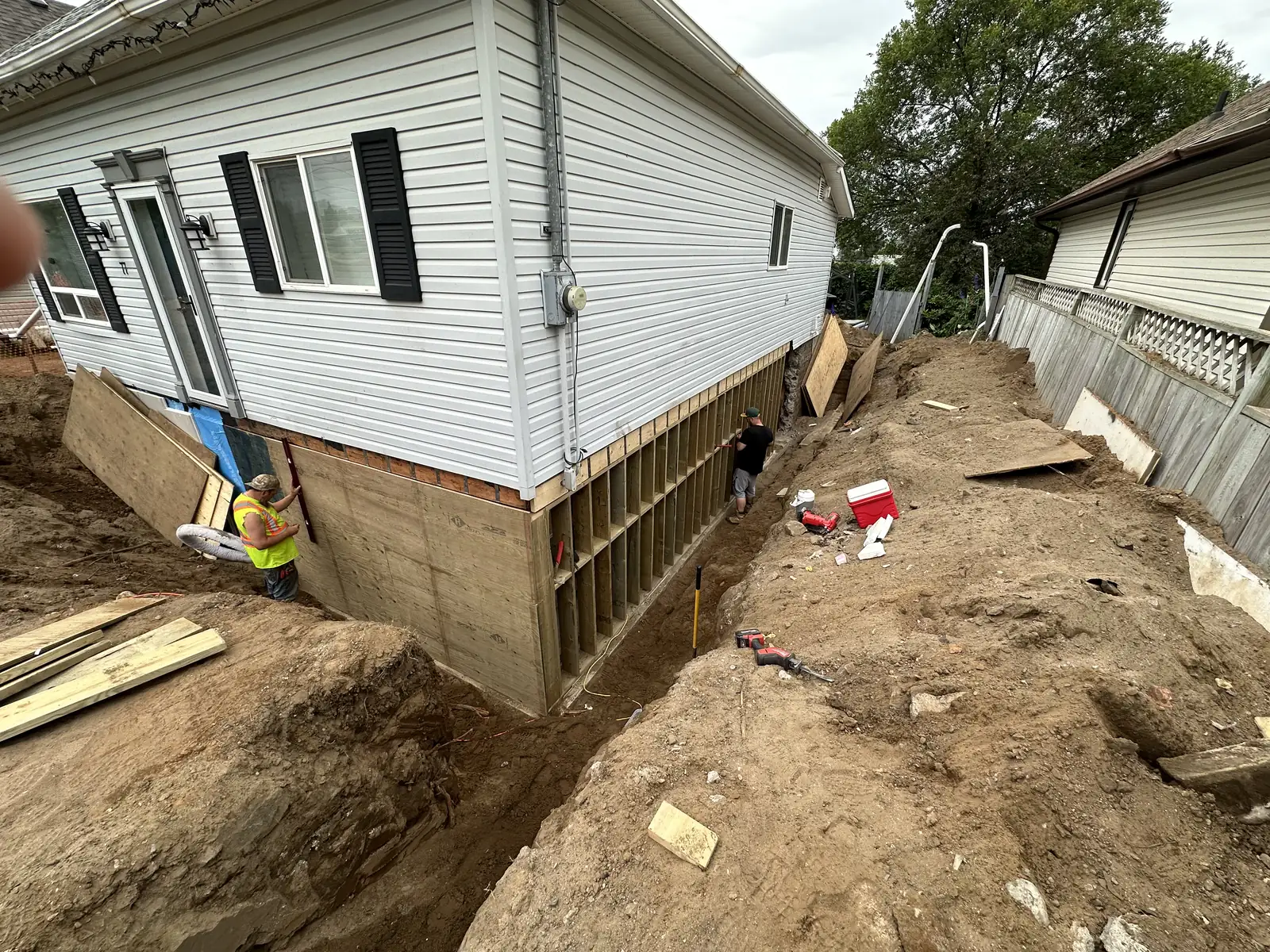 Crew working in a trench along a foundation wall